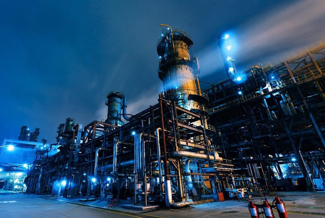 Oil refinery at night, lit control towers and pipework